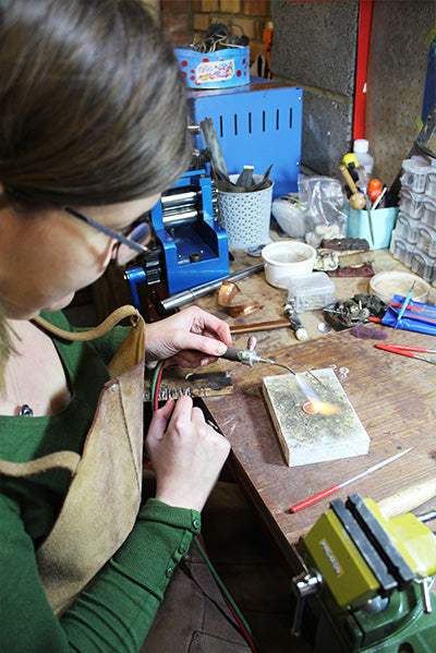 Gemma Tremayne, Jeweller Soldering at workbench 