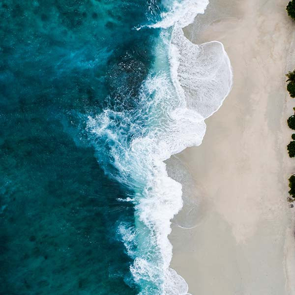 Ocean from above. Beautiful blue sea on white sands 