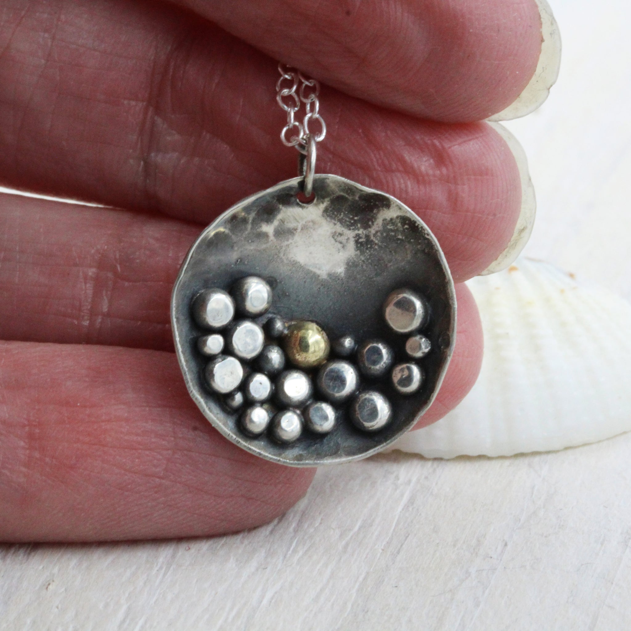 Pebbles on the Beach inspired sterling silver necklace, featuring a deep patina and silver pebble details 